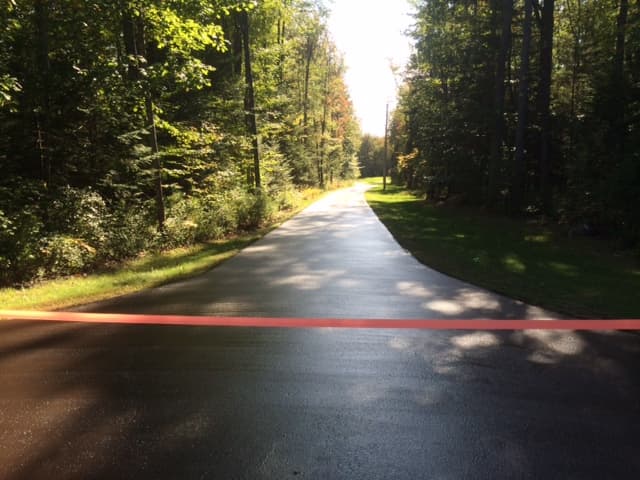 Wide open driveway with parking pad, fresh seal, roped off with PRC barrier tape