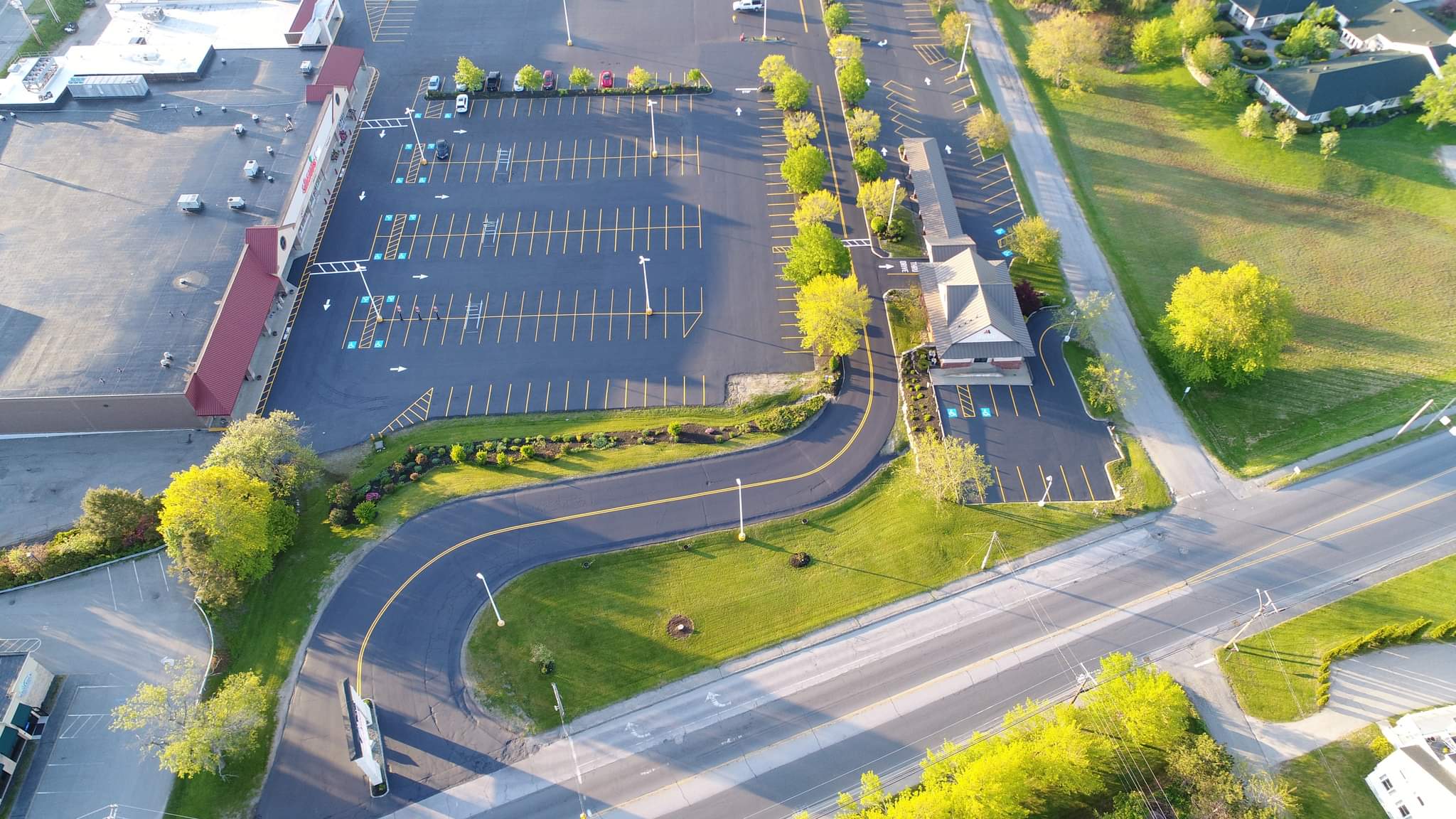 Aerial view of a fully striped retail parking lot, stalls, arrows, and ADA spaces marked